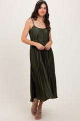 woman wearing a dark olive green pleated maxi dress with spaghetti straps and a flowing silhouette