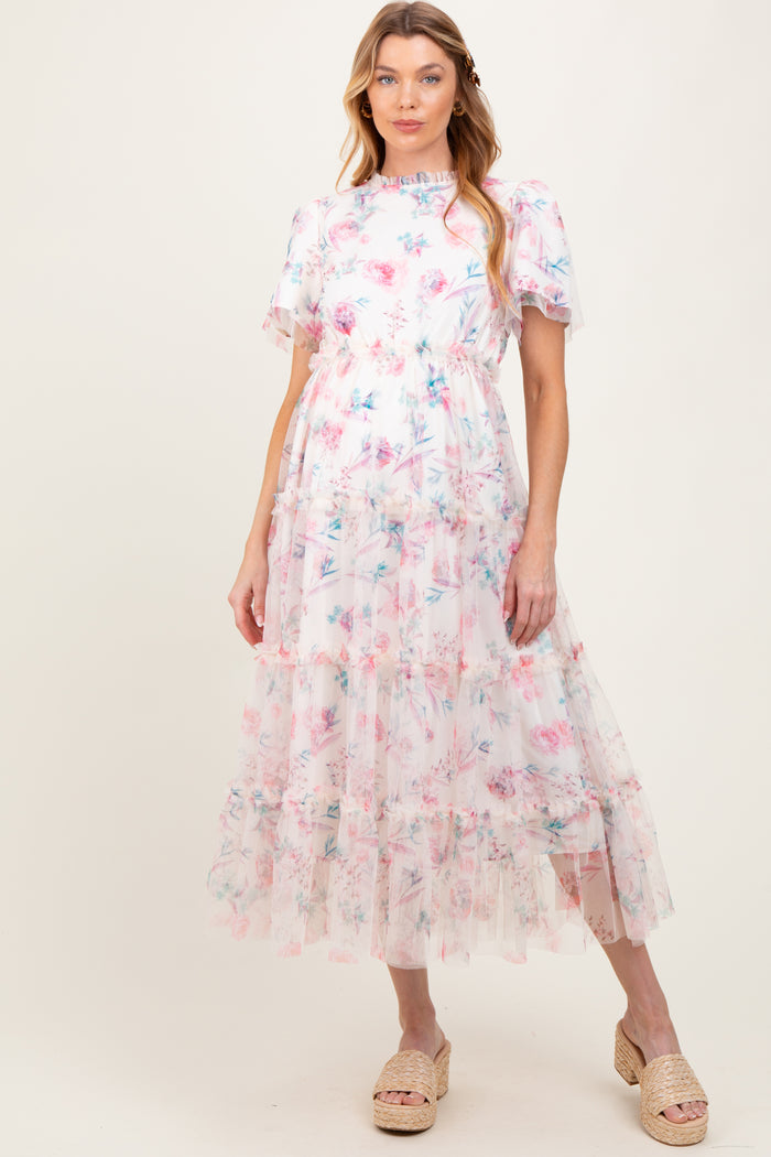 woman wearing a floral print maternity maxi dress with ruffle details and short sleeves, showcasing a baby bump