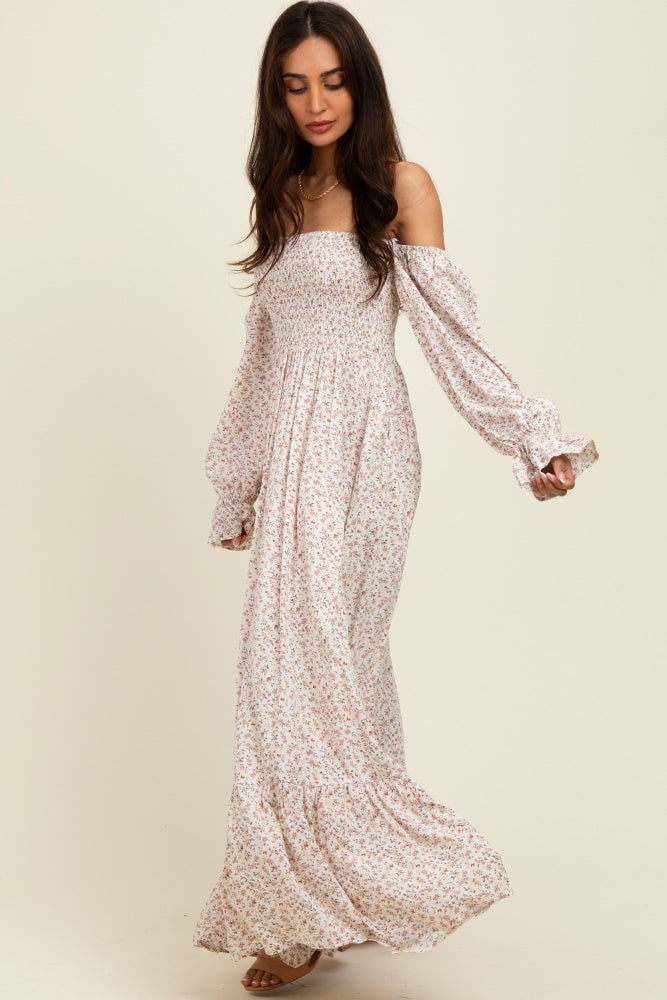 woman wearing a long off-the-shoulder floral maxi dress with puffed sleeves and a flowing skirt