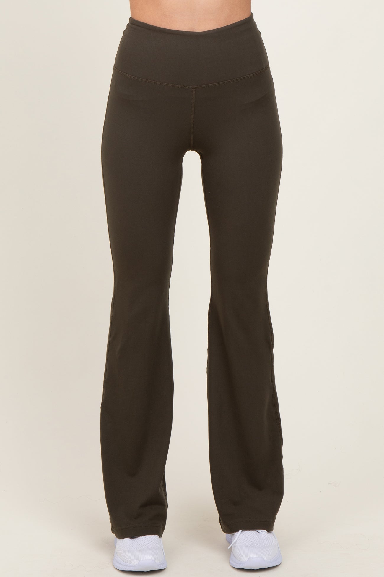 woman wearing black high-waisted flared yoga pants with a smooth finish and a fitted silhouette