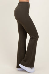 woman wearing olive green flared leggings with a high waist and white athletic shoes