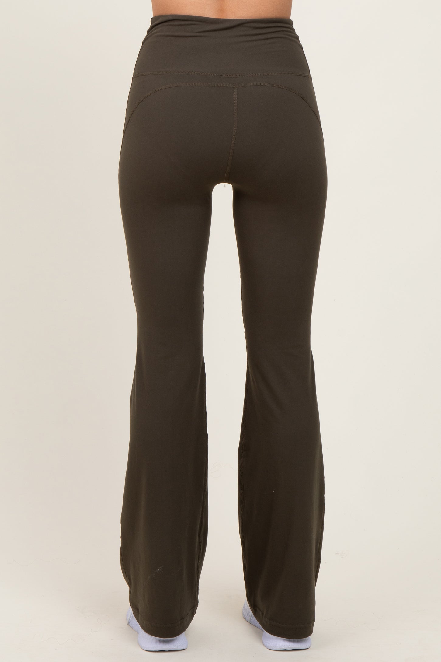 woman wearing dark green flared yoga pants viewed from the back