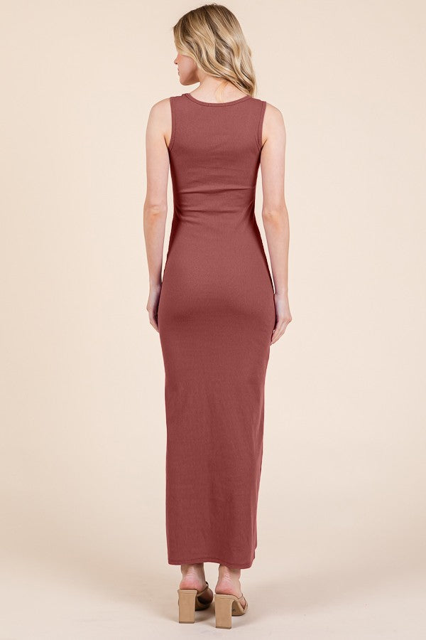 woman wearing a fitted rust-colored maxi dress, showing the back view, styled with open-toe heels