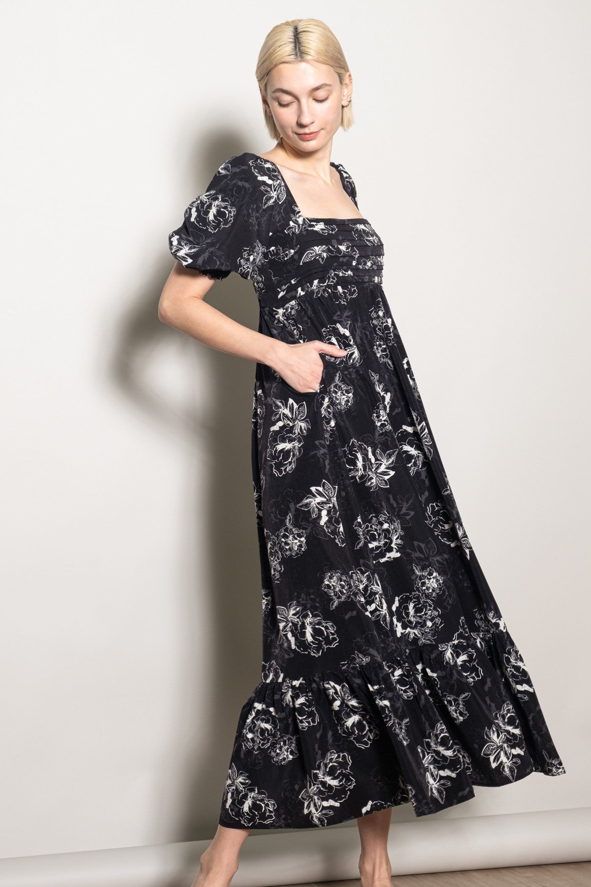 woman wearing a black floral maxi dress with puff sleeves and pockets