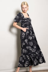 woman wearing a black floral maxi dress with puff sleeves and pockets