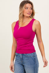 woman wearing a bright pink fitted tank top and light blue jeans