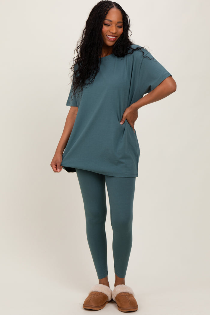 woman wearing a teal oversized t-shirt and matching leggings with pockets, styled casually with fuzzy slippers