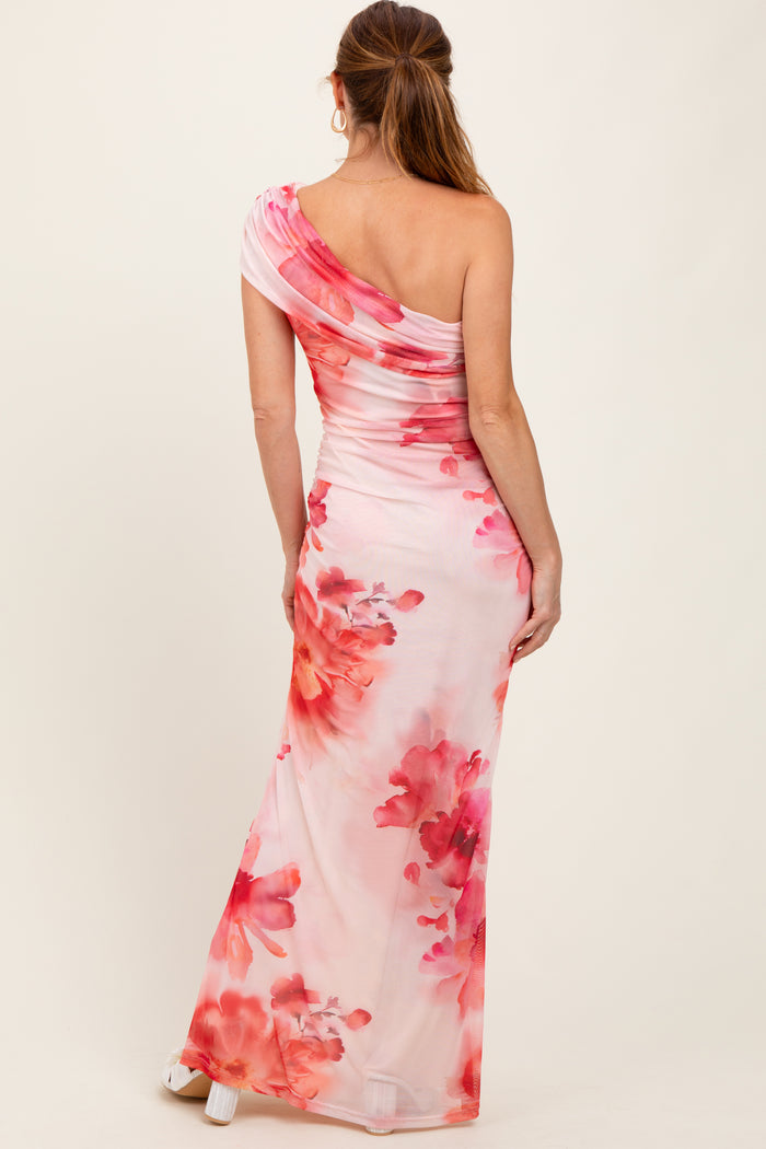 woman wearing a one-shoulder floral maxi dress in shades of pink and white with a fitted silhouette