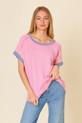 woman wearing a pink and blue striped short sleeve top with a relaxed fit paired with light blue jeans