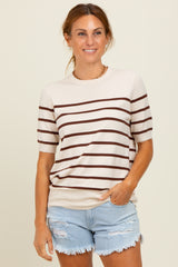 woman wearing a cream striped short sleeve sweater with brown stripes and denim shorts