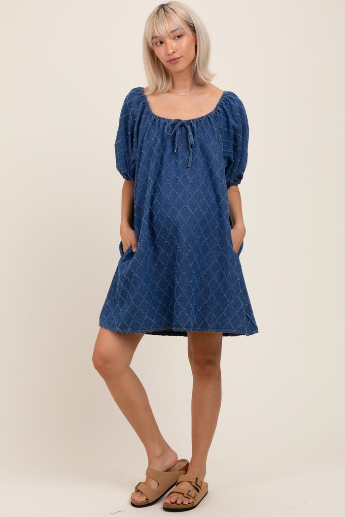 woman wearing a blue maternity dress with puff sleeves and a tie-front detail, showing a baby bump