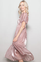 woman wearing a rose gold satin puff sleeve midi dress with a flowy skirt, smiling and posing sideways
