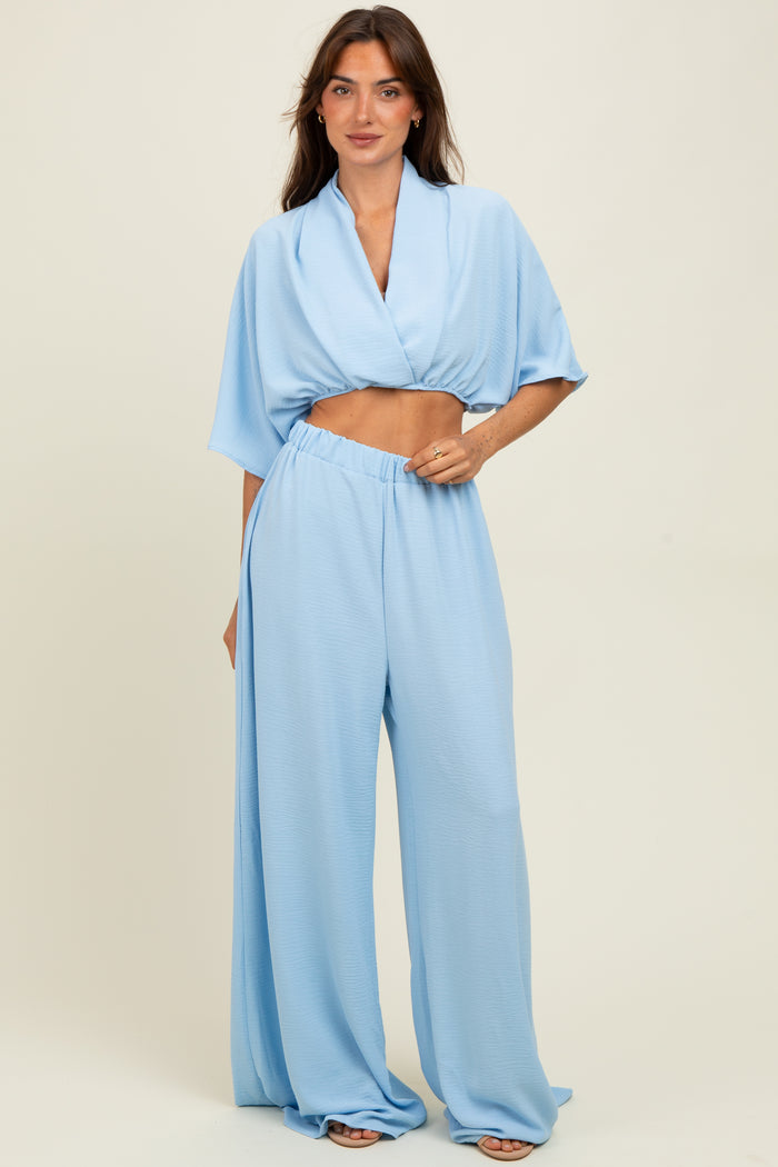 woman wearing a light blue two-piece set with a cropped top and wide-leg pants