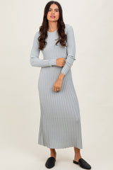 woman wearing a light gray ribbed long sleeve maxi dress and black flat slides