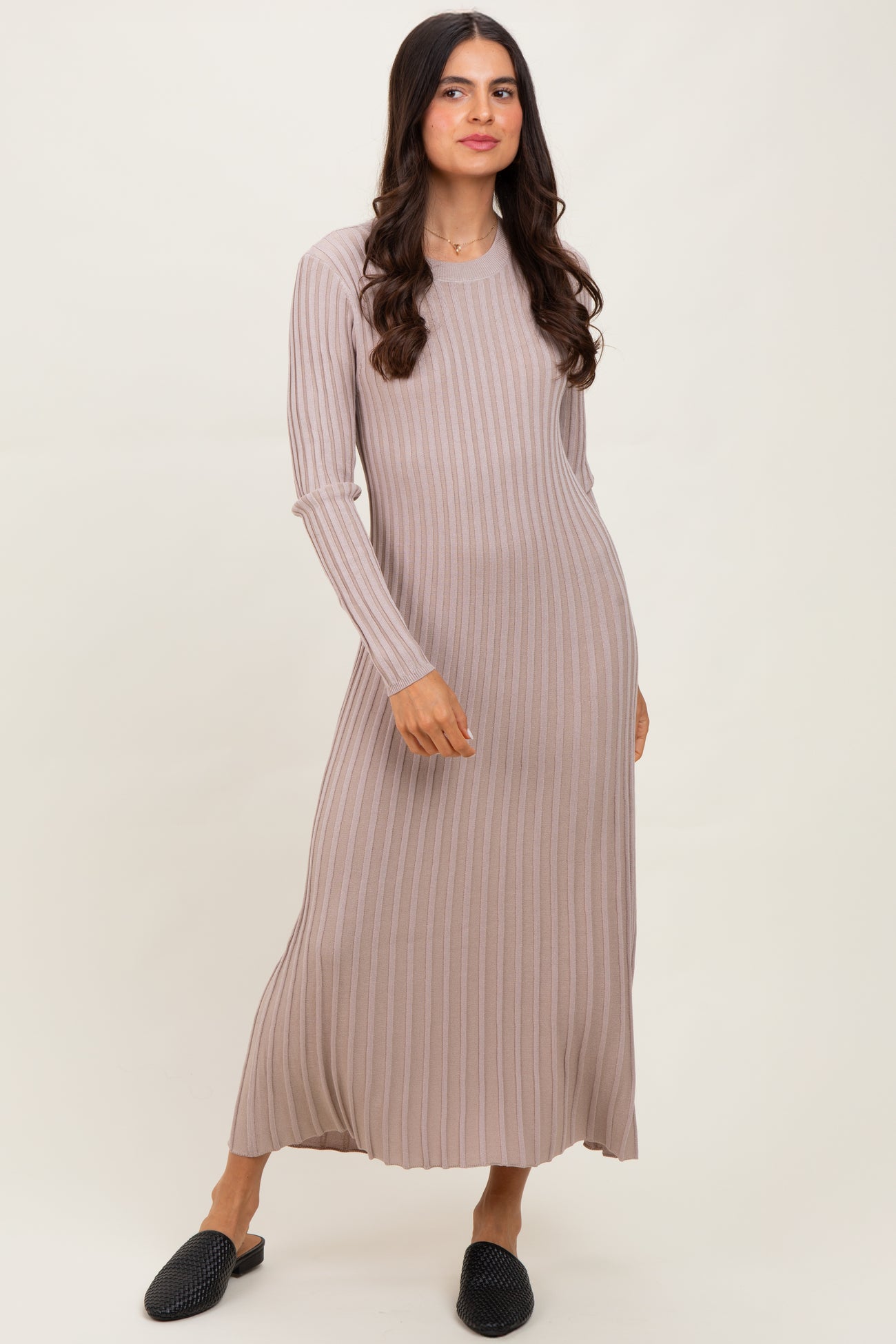 woman wearing a light taupe long sleeve ribbed maxi dress and black slip-on shoes