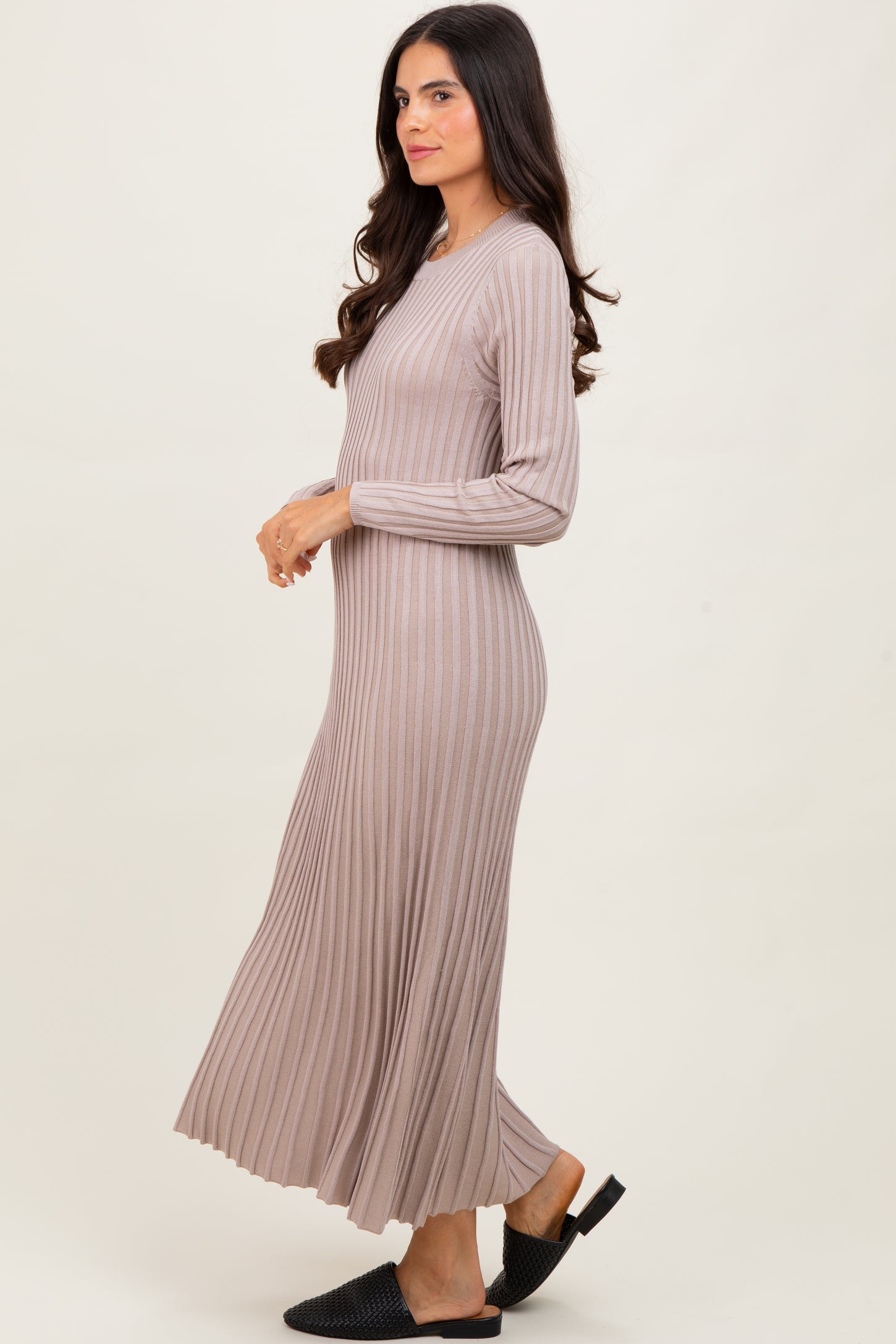 woman wearing a beige ribbed long sleeve maxi dress with a flared skirt and open-toe black sandals