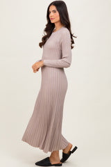 woman wearing a beige ribbed long sleeve maxi dress with a flared skirt and open-toe black sandals