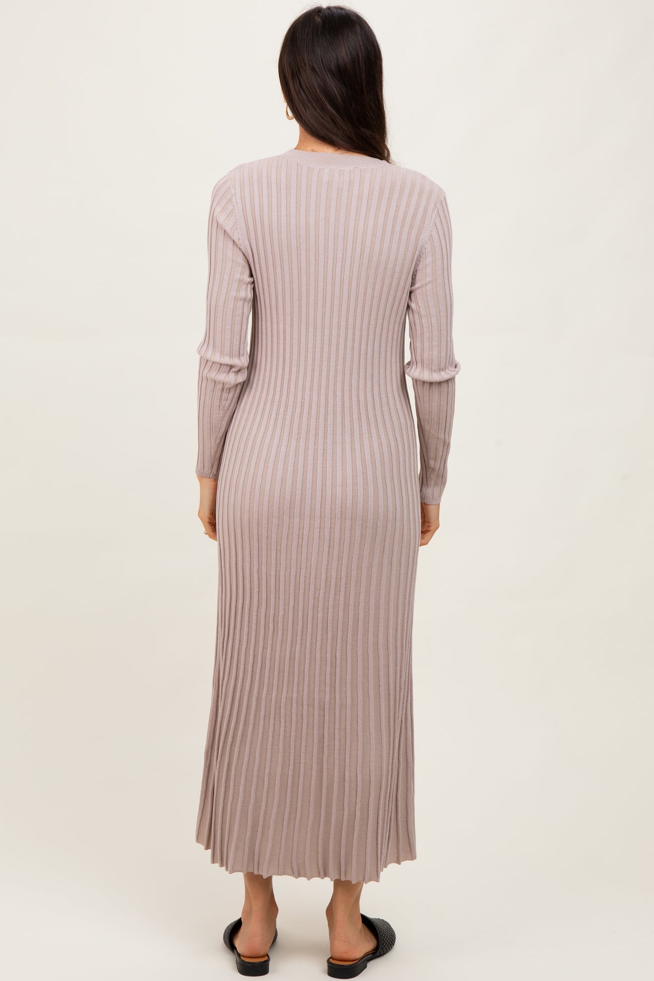 woman wearing a long sleeve ribbed taupe maxi dress, view from the back