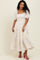 woman wearing a white floral maxi dress with puff sleeves and a square neckline, paired with pink heels