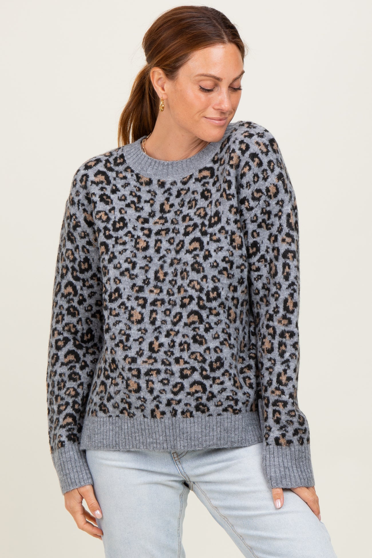 woman wearing a gray leopard print sweater with a relaxed fit and ribbed cuffs and hem
