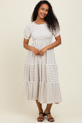 woman wearing a cream and brown striped midi dress with short sleeves and tiered ruffles