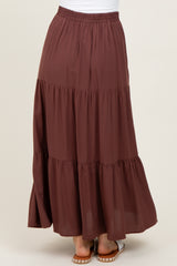 woman wearing a burgundy tiered maxi skirt with an elastic waist and flowy fabric