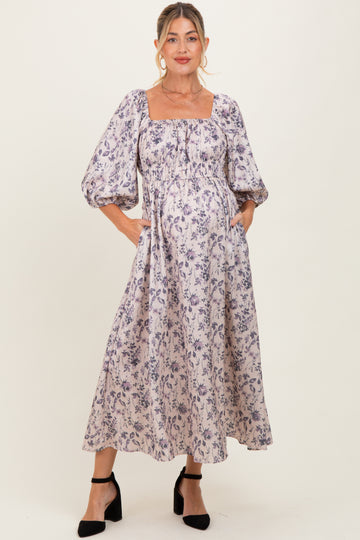 woman wearing a floral print maternity dress with puff sleeves and a square neckline, highlighting her baby bump