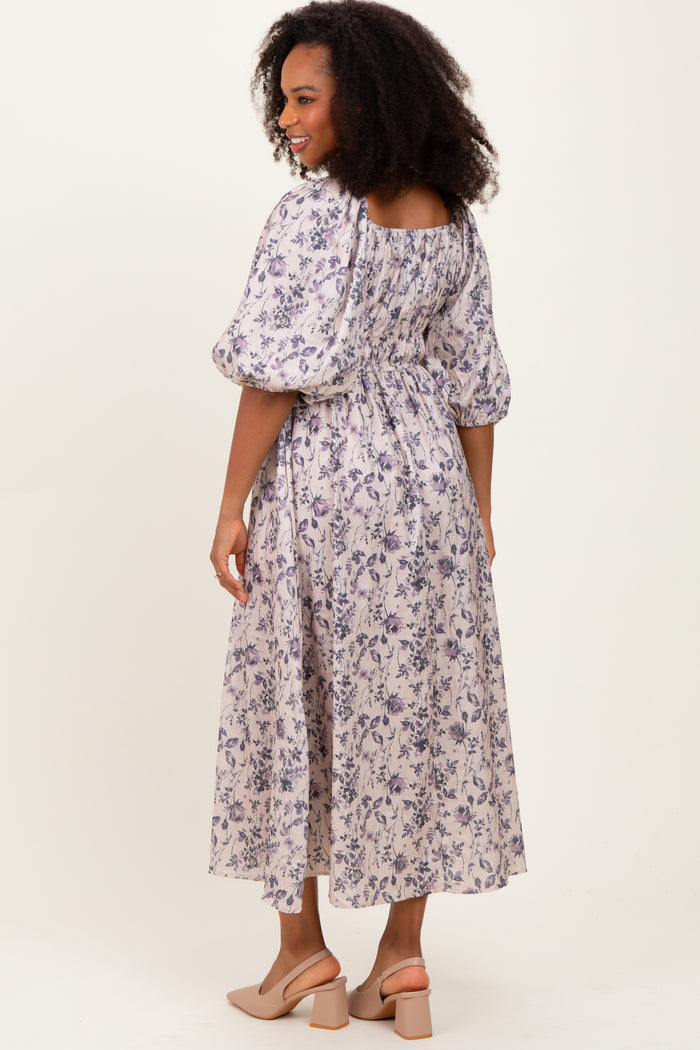 woman wearing a purple floral mid-length dress with puff sleeves and a smocked back