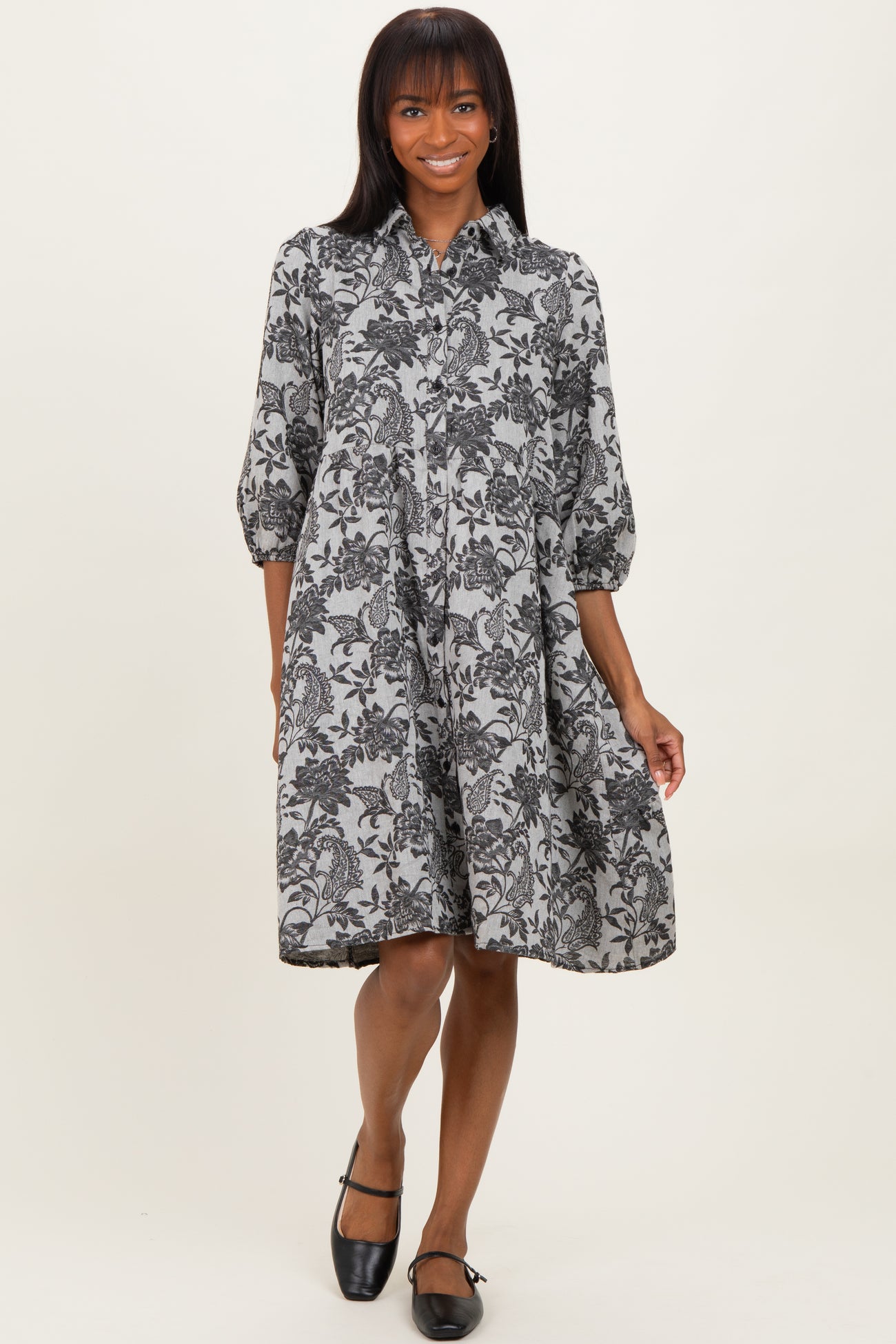 woman wearing a black and white floral print shirt dress with three-quarter sleeves and a relaxed fit