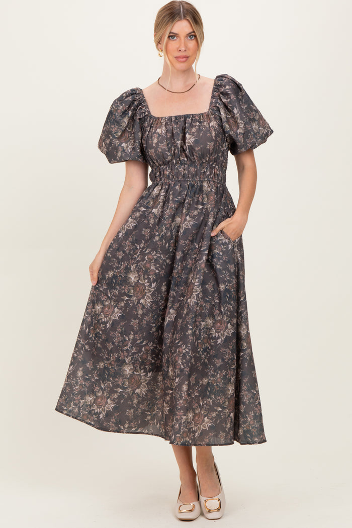 woman wearing a dark floral print maxi dress with puff sleeves and pockets