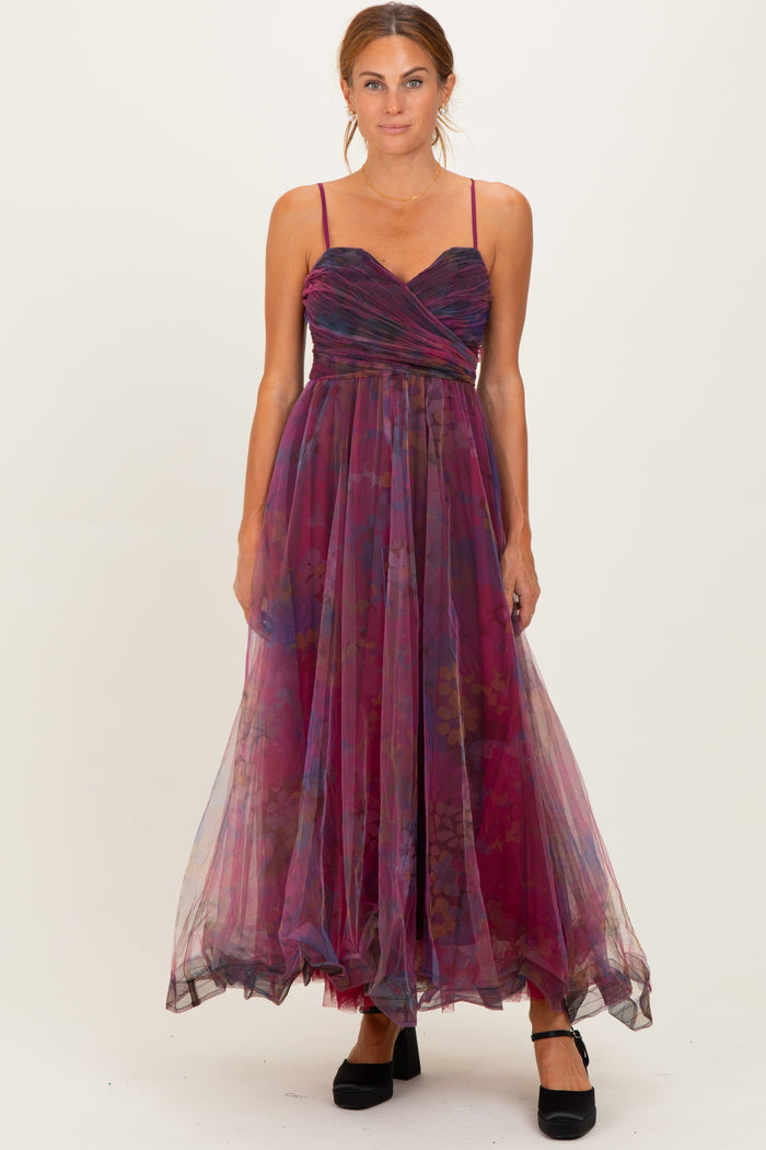 woman wearing a plum and floral maxi dress with spaghetti straps and a fitted bodice, standing in a flowy tulle skirt