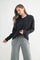 woman wearing a black long sleeve shirt and gray sweatpants with a relaxed fit