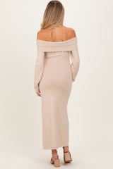 woman wearing a beige off-the-shoulder knitted maternity dress with long sleeves and a form-fitting silhouette