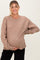 woman wearing a taupe oversized maternity sweater and holding her baby bump