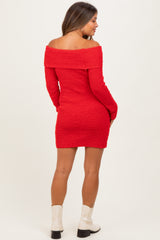 woman wearing a red off-the-shoulder maternity dress with long sleeves and a fitted silhouette