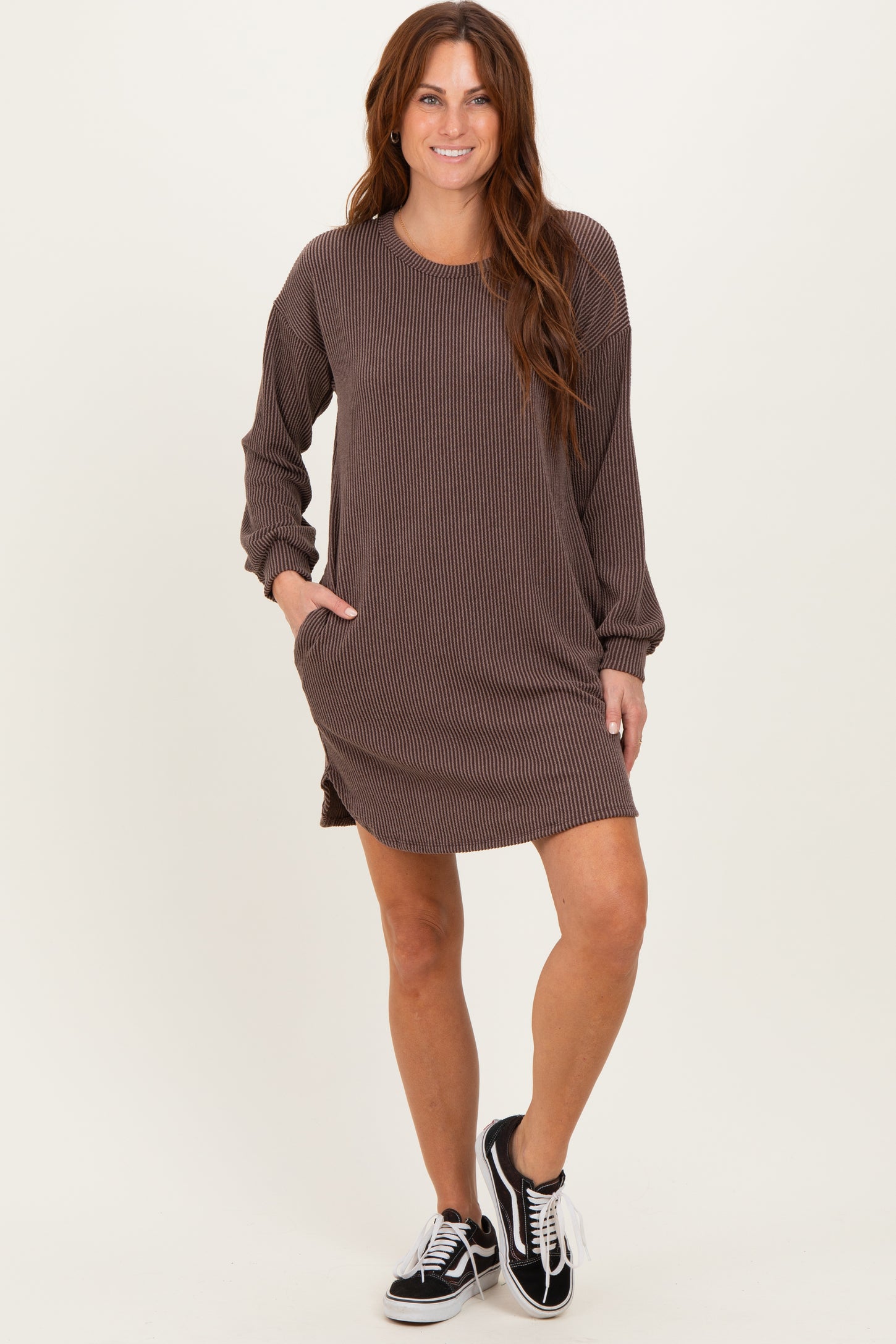woman wearing a brown striped long sleeve dress with side pockets and a relaxed fit