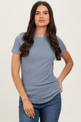 woman wearing a light blue ribbed short sleeve top and blue jeans with a casual pose