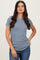 woman wearing a light blue ribbed short sleeve top and blue jeans with a casual pose