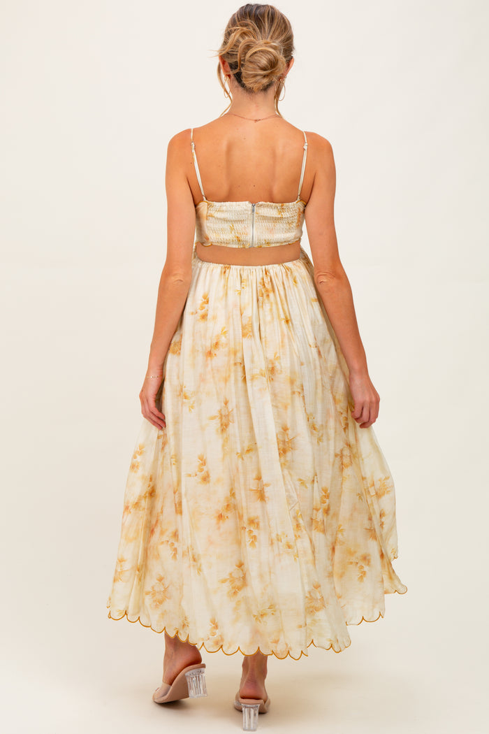 woman wearing a floral print maternity dress with a smocked bodice and a flowy skirt, showing a baby bump from behind