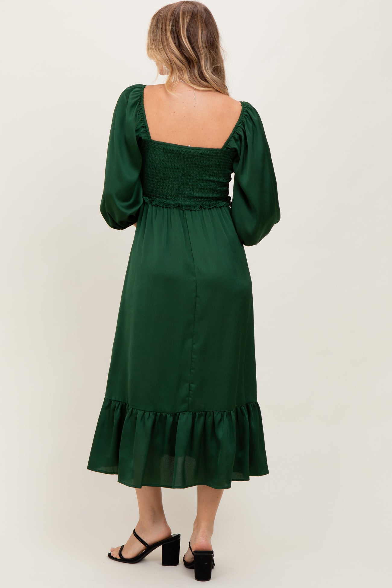 woman wearing a green puff sleeve midi dress with smocked bodice and ruffle hem, shown from the back