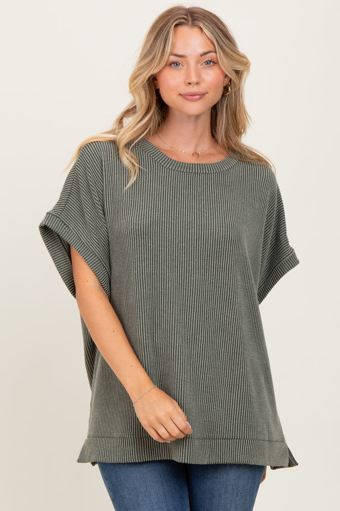 woman wearing a relaxed fit olive green ribbed knit top with short sleeves and side slits, paired with jeans