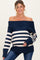 woman wearing a navy and cream striped off-the-shoulder maternity sweater and showing her baby bump