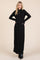 woman wearing a black long sleeve maxi dress with a zippered neckline and a fitted silhouette