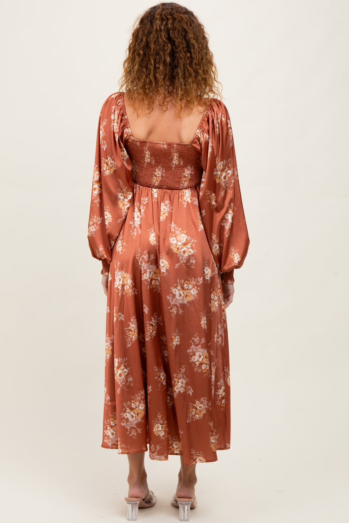 woman wearing a rust floral midi dress with puff sleeves and a smocked bodice, shown from the back