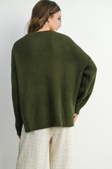 woman wearing an olive green oversized knit sweater with a relaxed fit and dropped shoulders, viewed from the back