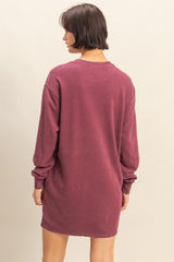 woman wearing a maroon long sleeve oversized sweatshirt dress, viewed from the back