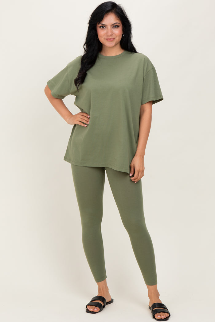 woman wearing an olive green oversized t-shirt and matching leggings, standing with one hand on her hip