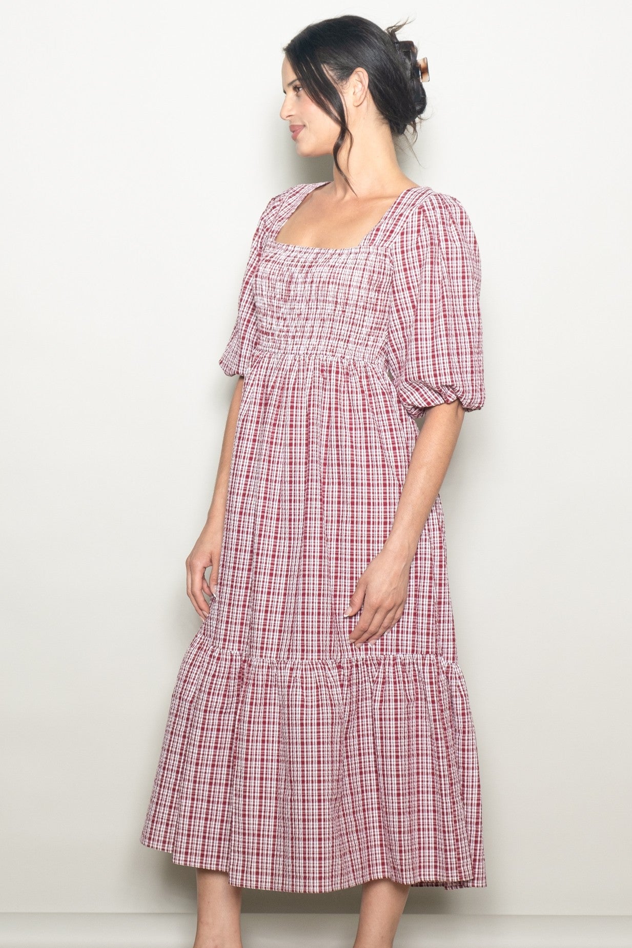woman wearing a red and white checkered maxi dress with puff sleeves and gathered bodice