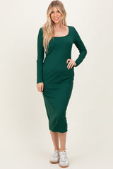 woman wearing a dark green long sleeve midi dress with a square neckline and white sneakers