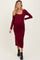 woman wearing a burgundy long sleeve maternity dress that highlights her baby bump